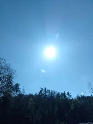 a sun in the sky over a forest of trees at Penzion Litohlavy 17 - Na samotě u lesa in Králŭv Dvŭr