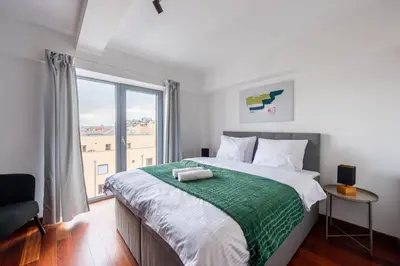 a bedroom with a large bed with a large window at Stylish penthouses featuring a terrace in Prague in Prague