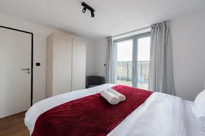a bedroom with a bed with a red and white blanket at Stylish penthouses featuring a terrace in Prague in Prague