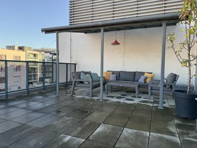 a white building with cars parked in a parking lot at Penthouse with terrace near the center of Prague in Prague