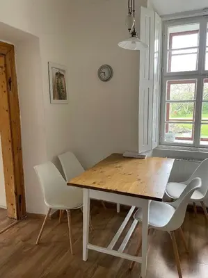 a dining room with a table and white chairs at Kamenný dům s výhledem na zámek 20km od Prahy in Nižbor