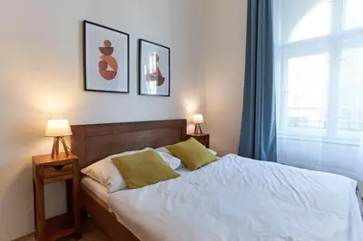 a bedroom with a bed with two lamps and a window at Narodni - Old Town Residence in Prague