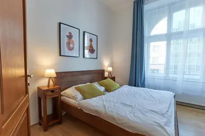 a bedroom with a bed and a large window at Narodni - Old Town Residence in Prague