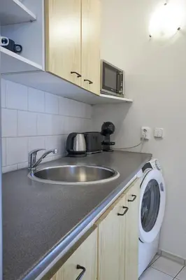 a kitchen with a sink and a washing machine at Narodni - Old Town Residence in Prague