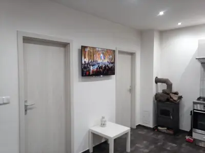 a living room with a television on the wall at Nižbor samostatný domek v zahradě in Nižbor