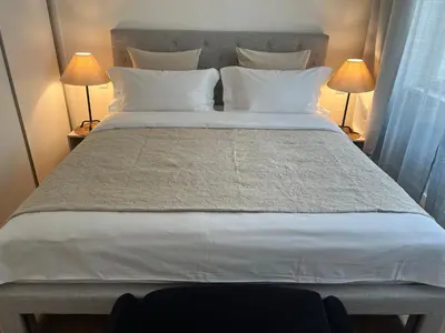 a large bed with white pillows and two lamps at CITY CENTRUM CHARMING apartment in Prague