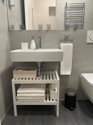 a bathroom with a sink and a shelf with towels at CITY CENTRUM CHARMING apartment in Prague