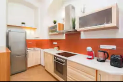 a kitchen with a refrigerator and a stove top oven at LuxePair Suites Near Prague Castle in Prague