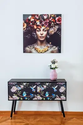 a painting of a woman on a table with a vase at LuxePair Suites Near Prague Castle in Prague