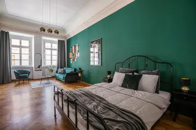 a bedroom with green walls and a bed in a room at LuxePair Suites Near Prague Castle in Prague