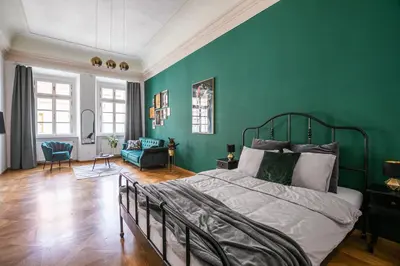 a bedroom with a bed and a green wall at LuxePair Suites Near Prague Castle in Prague