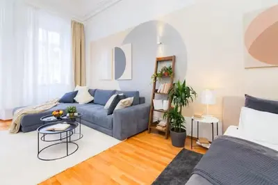 a living room with a blue couch and a table at LuxePair Suites Near Prague Castle in Prague