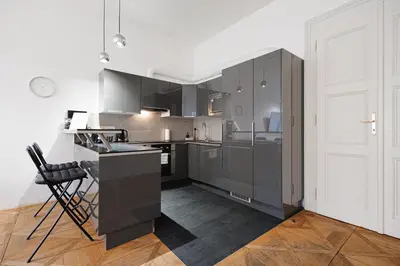 a kitchen with gray cabinets and a black counter at Exclusive apartment near Kafka's head in Prague