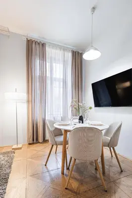 a dining room with a table and chairs and a tv at Exclusive apartment near Kafka's head in Prague