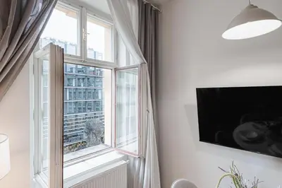 a living room with a window and a flat screen tv at Exclusive apartment near Kafka's head in Prague