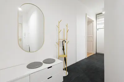 a white bathroom with a mirror and a sink at Exclusive apartment near Kafka's head in Prague