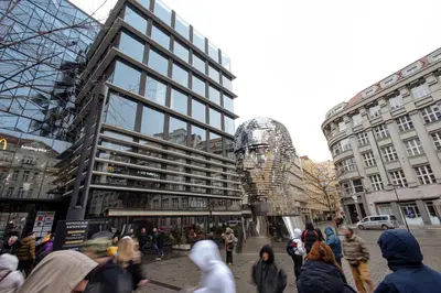 a group of people walking in a city with buildings at Exclusive apartment near Kafka's head in Prague