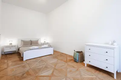 a white bedroom with a bed and a dresser at Exclusive apartment near Kafka's head in Prague