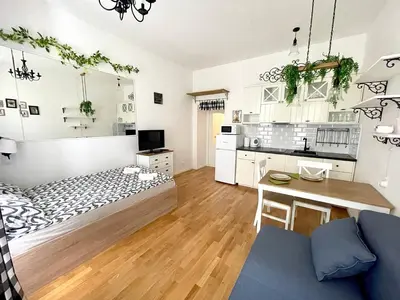 a bedroom with a bed and a desk and a kitchen at Centrum Bohemia Apartment in Prague
