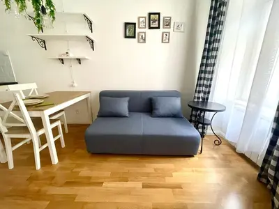 a living room with a blue couch and a table at Centrum Bohemia Apartment in Prague