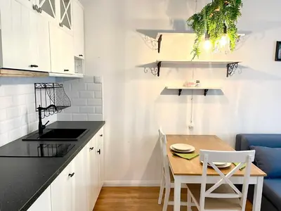 a kitchen with white cabinets and a table and chairs at Centrum Bohemia Apartment in Prague