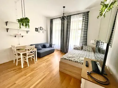 a living room with a blue couch and a table at Centrum Bohemia Apartment in Prague
