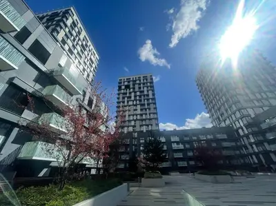 a sun is shining in a city with tall buildings at Centrum Park Studio in Prague