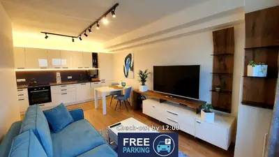 a living room with a blue couch and a flat screen tv at LUXURY APARTMENT VBLOKU in Prague