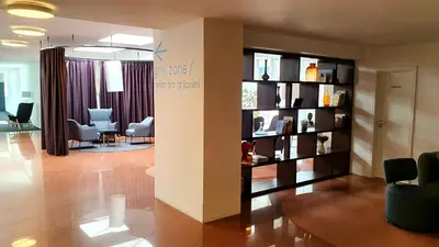 a living room with a waiting room with chairs and a book shelf at LUXURY APARTMENT VBLOKU in Prague