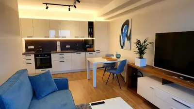 a living room with a blue couch and a kitchen at LUXURY APARTMENT VBLOKU in Prague