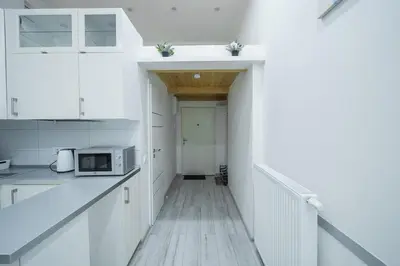 a kitchen with white cabinets and a microwave at Opletal Apartment Prague in Prague