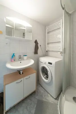 a bathroom with a washing machine and a sink at Opletal Apartment Prague in Prague
