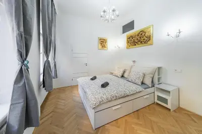 a small white bedroom with a bed in it at Opletal Apartment Prague in Prague