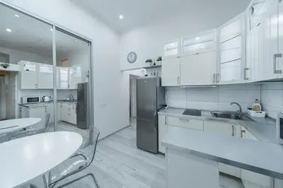 a kitchen with white cabinets and a stainless steel refrigerator at Opletal Apartment Prague in Prague