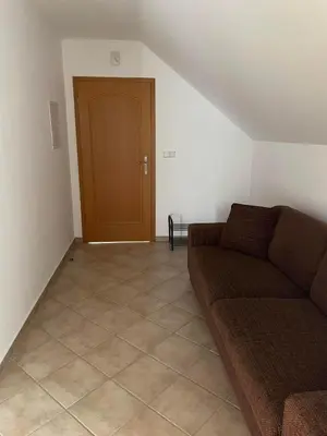 a living room with a couch and a wooden door at Apartmán Tereza in Poděbrady