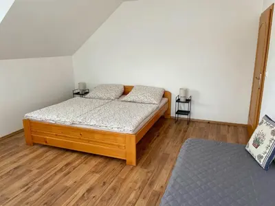 a bedroom with two beds and a wooden floor at Apartmán Tereza in Poděbrady