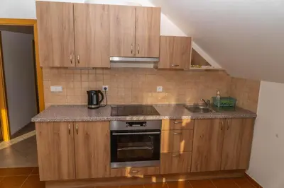 a kitchen with wooden cabinets and a stove and a sink at Apartmán Tereza in Poděbrady