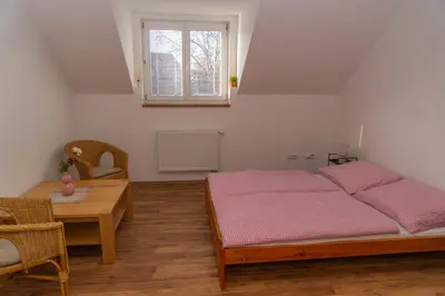 a bedroom with two beds and a table and a window at Apartmán Tereza in Poděbrady