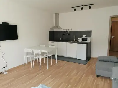 a kitchen and dining room with a table and chairs at Brand new studio apartment #21 with free secure parking in the center in Prague
