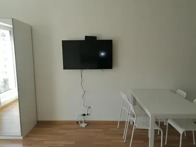 a dining room with a table and a tv on the wall at Brand new studio apartment #21 with free secure parking in the center in Prague