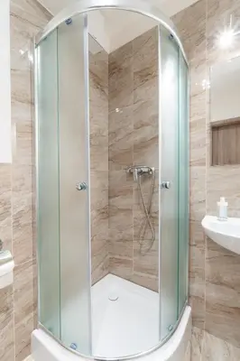 a shower with a glass door in a bathroom at Brand new studio apartment #21 with free secure parking in the center in Prague
