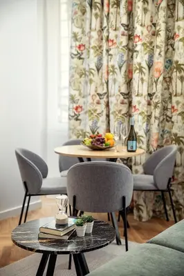 a table with chairs and a table with a bowl of fruit at Soukenicka Apartments Old Town Prague in Prague