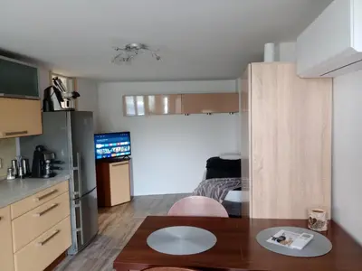 a living room with a table and a kitchen at Apartmán Marie in Litoměřice