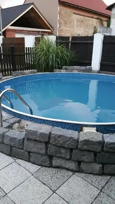 a swimming pool with a stone wall around it at Apartmán Marie in Litoměřice