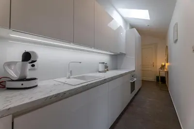 a white kitchen with a counter and a sink at Luxurious, charming studio perfect for couples in Prague