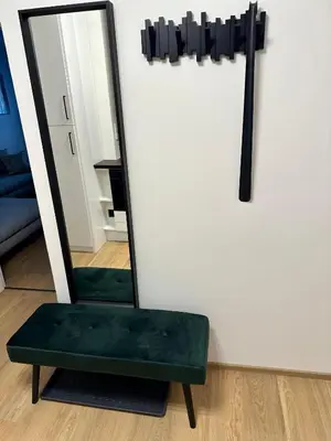 a green chair sitting in front of a mirror at Apartmán Panenská in Prague