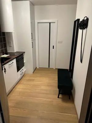 a kitchen with a hallway with a chair and a door at Apartmán Panenská in Prague