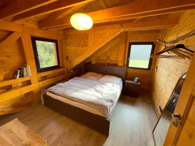 a bedroom in a log cabin with a bed in it at Chata Křivoklát in Křivoklát