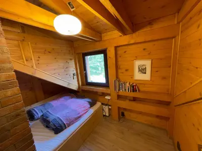 a room with a bed in a wooden cabin at Chata Křivoklát in Křivoklát