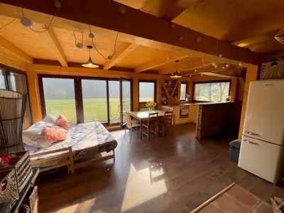 a large living room with a refrigerator and a table at Chata Křivoklát in Křivoklát
